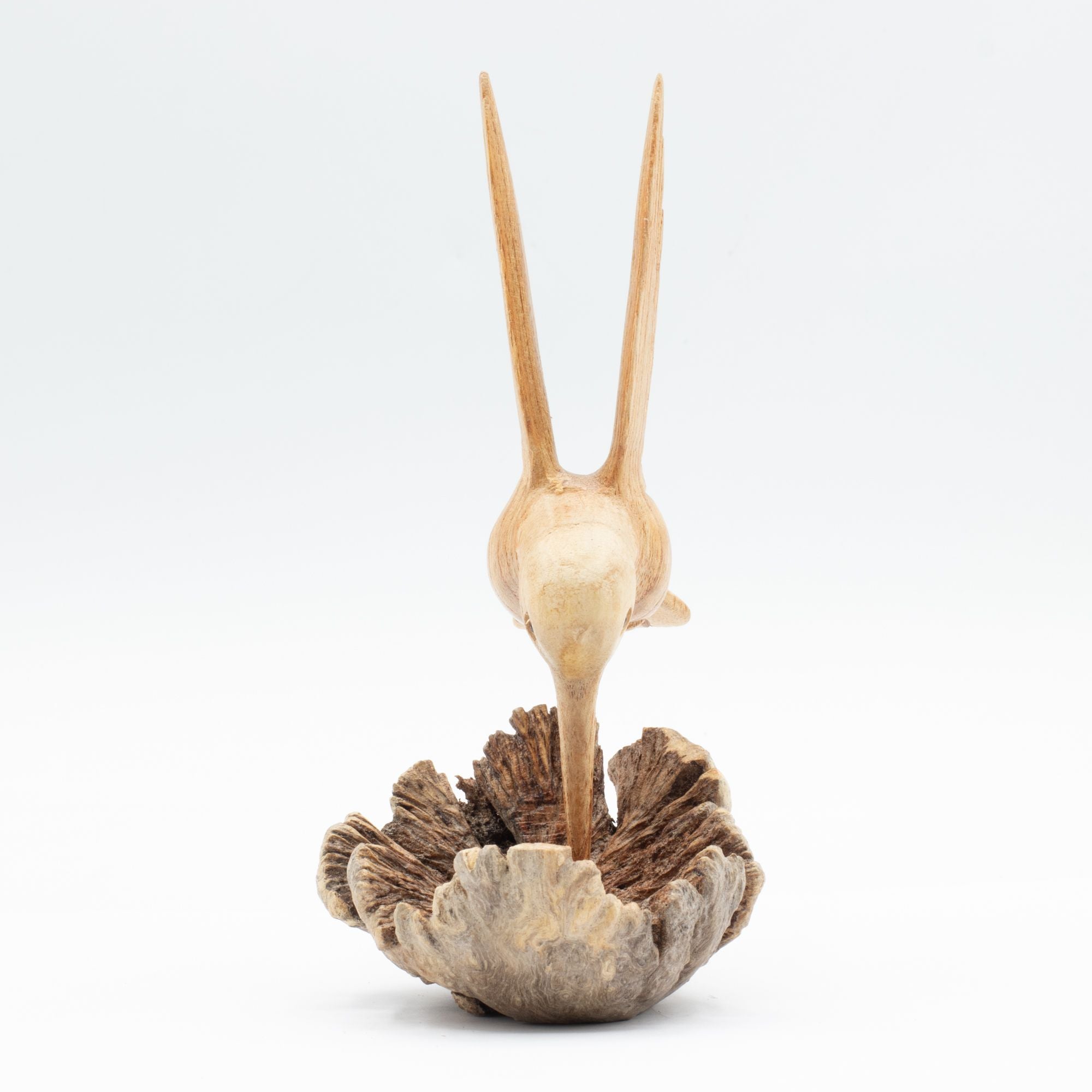 Sculpture artisanale d'un colibri buvant du nectar sur une excroissance d'arbre