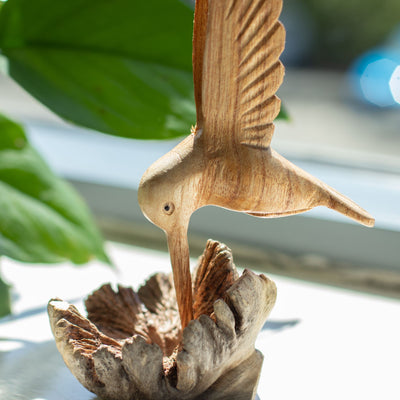 Sculpture artisanale d'un colibri buvant du nectar sur une excroissance d'arbre